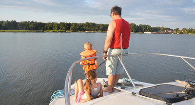 Vader en kinderen aan boord van een boot